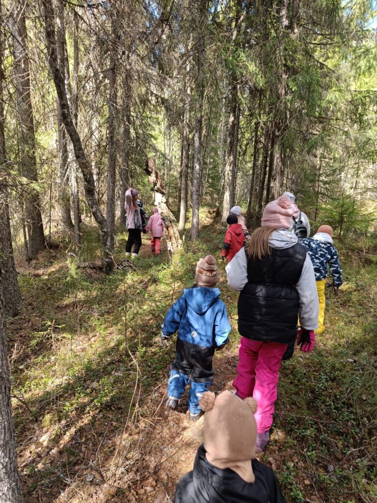 Taistelijan talon luontokerhossa, lapset vaeltavat metsäretkellä aikuisen kanssa.